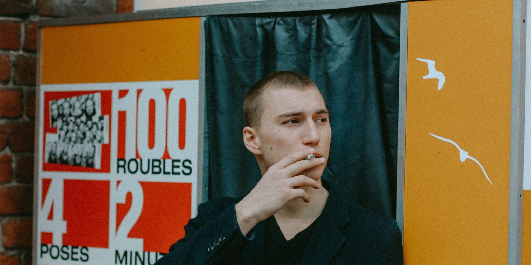 man-smoking-in-front-of-photo-booth-2183909