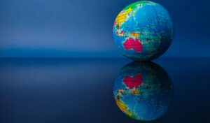 Wereldbol weerspiegeld op een tafel.